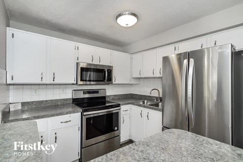 A kitchen with white cabinets and stainless steel appliances.