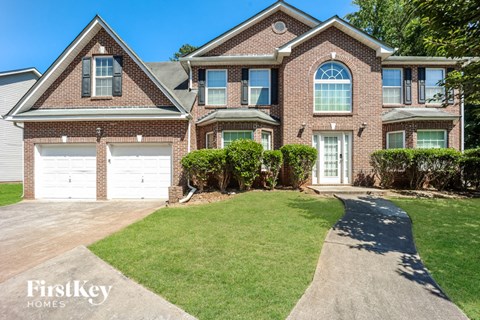a large brick house with two garage doors in front of it
