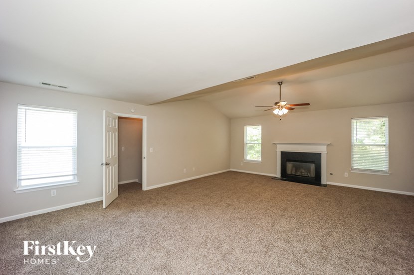 a living room with a fireplace and a ceiling fan