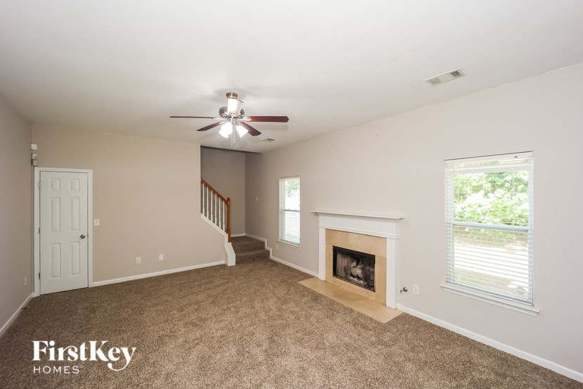 a living room with a fireplace and a ceiling fan