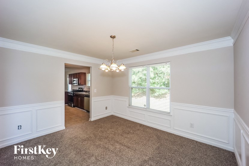 an empty dining room with white walls and a large window