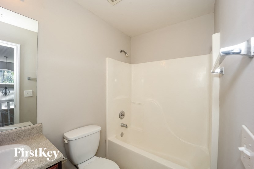 a white bathroom with a toilet and a tub