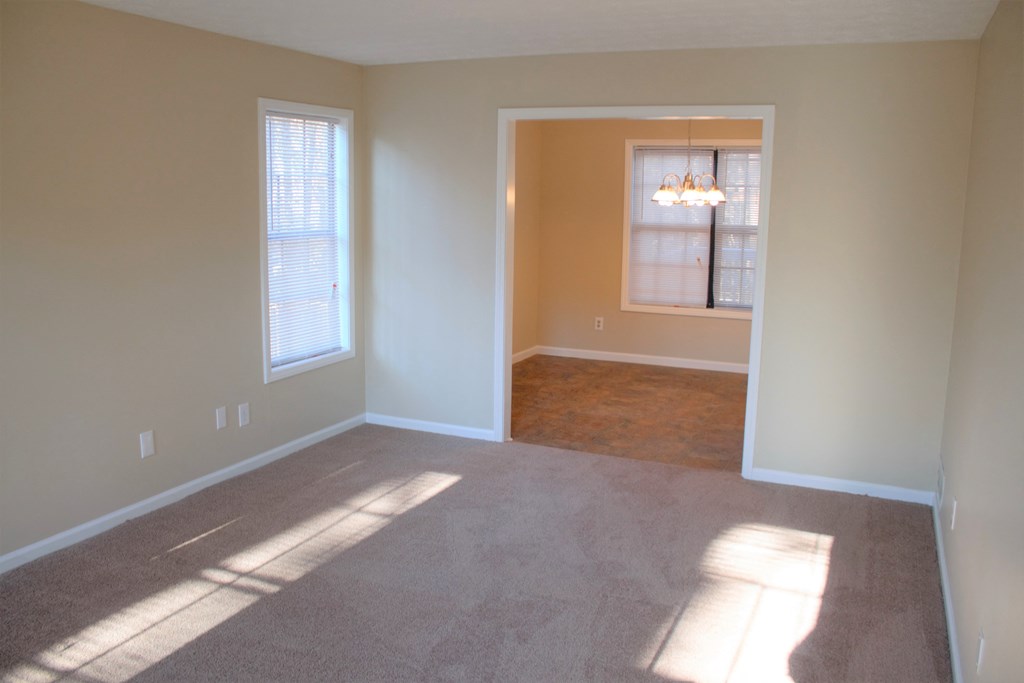 A room with a carpeted floor and a window.