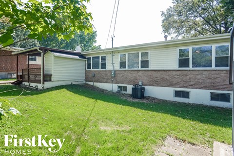 the backyard of a brick house with a yard and grass