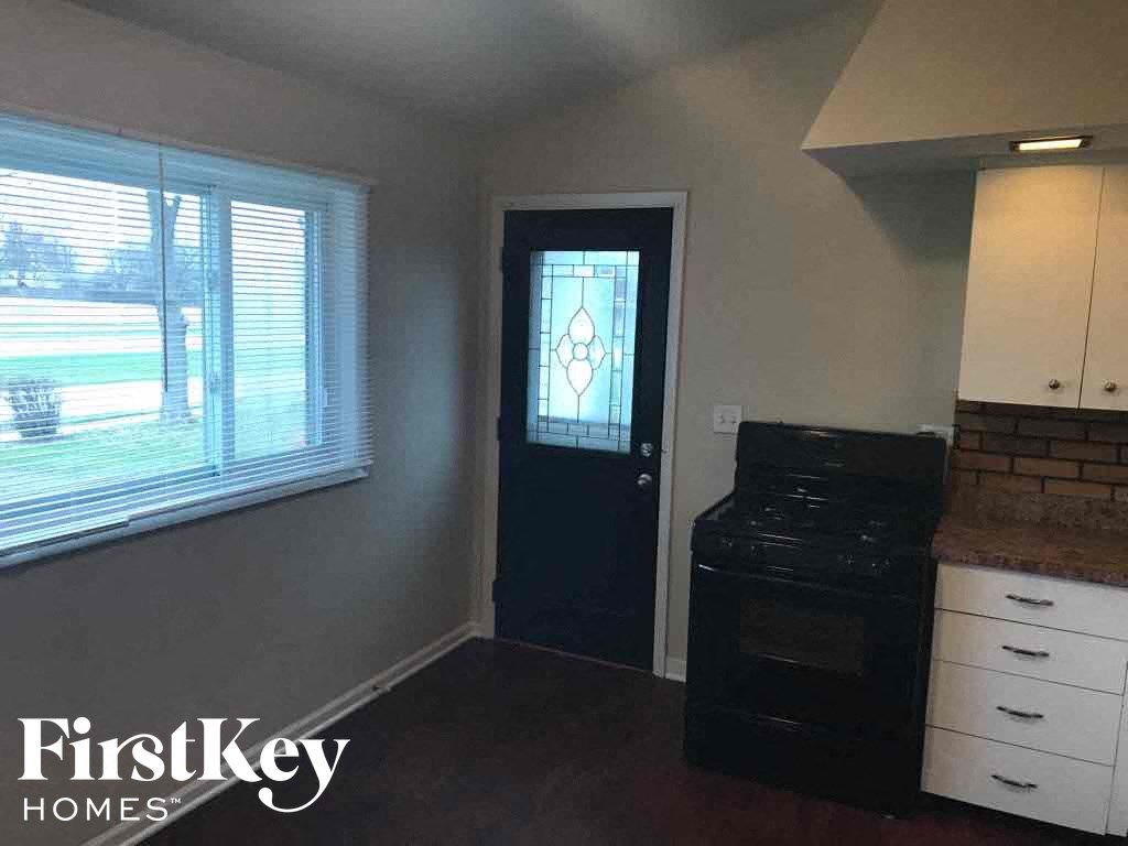 a kitchen with a stove and a door with a window