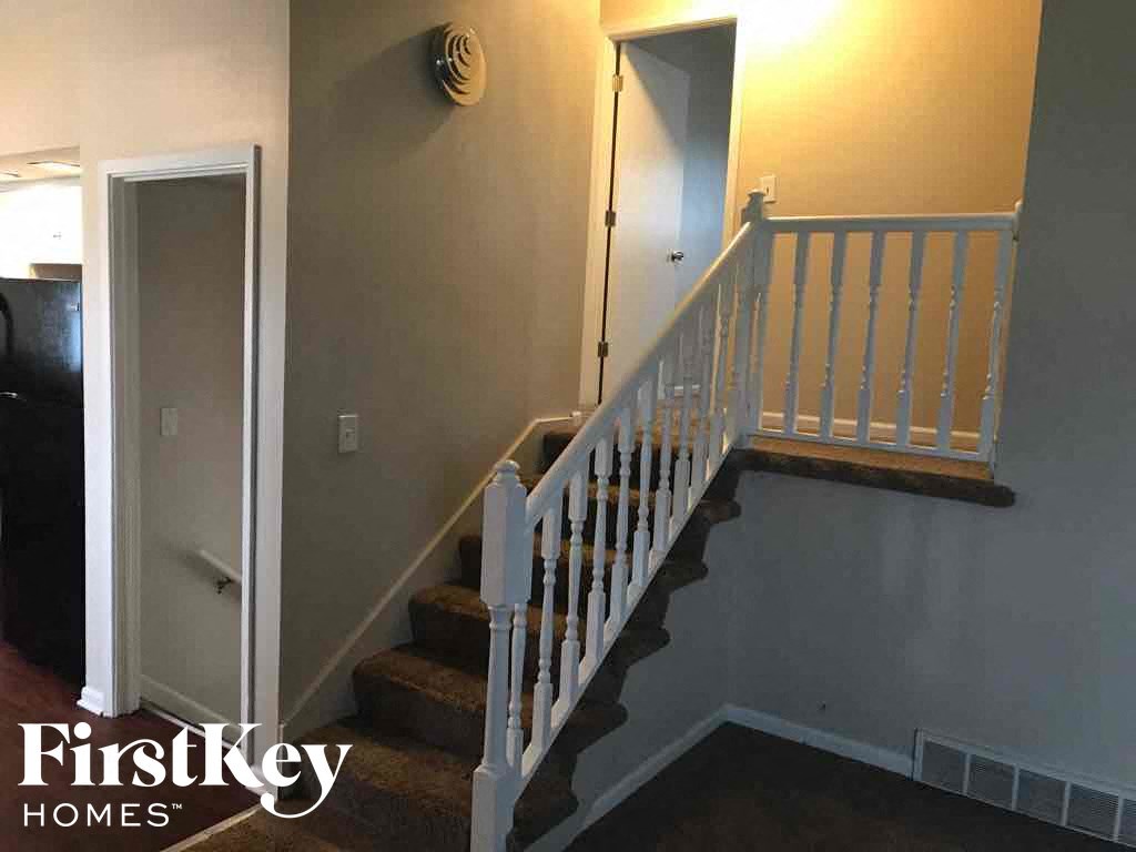 a stairway in a house with a white staircase and a door