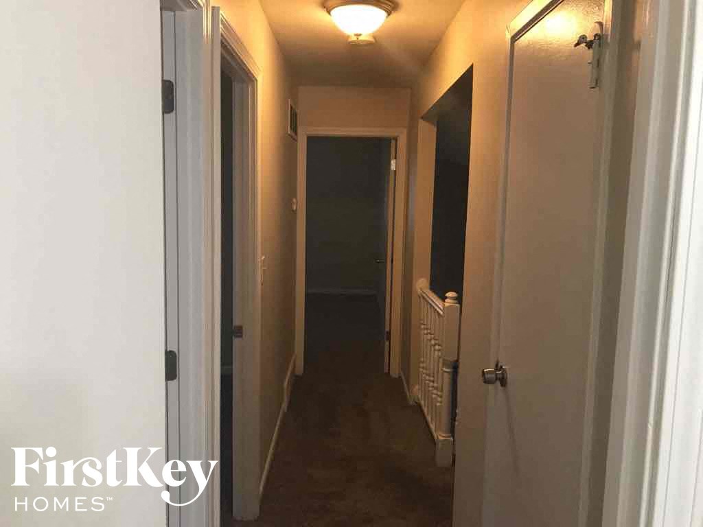 a hallway with a white door and a hall way with a door to a closet