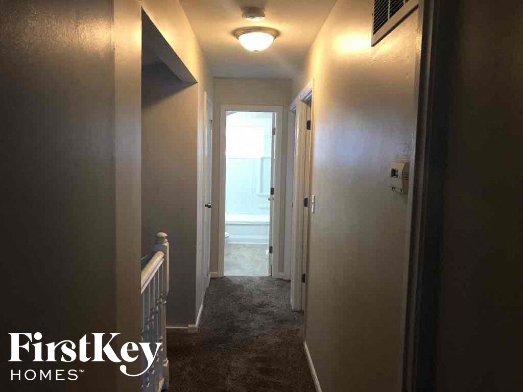 a hallway in a house with a door to a bathroom and a hallway with a