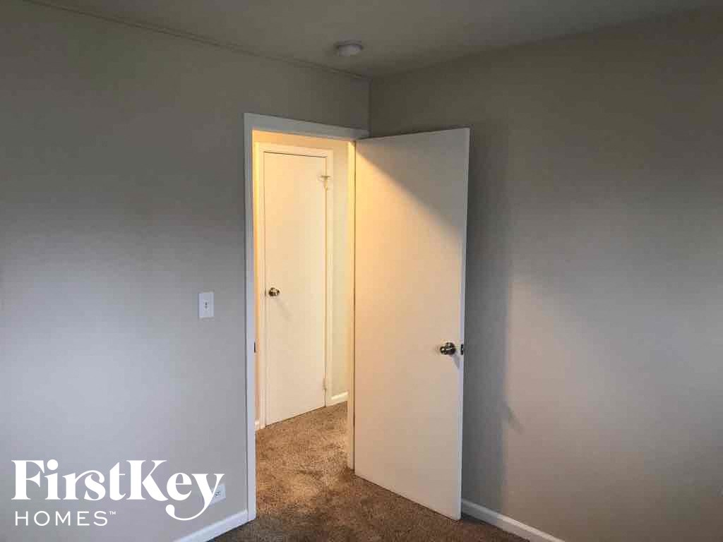 an empty room with a door open to a closet