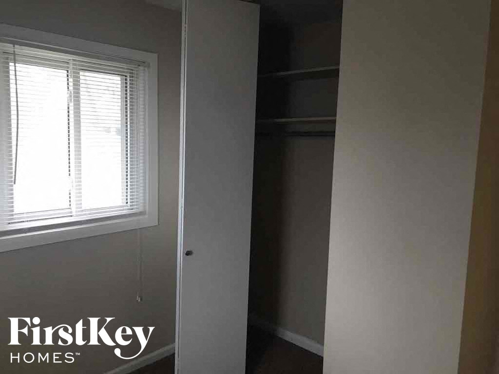 a room with a closet and a window and a mirror