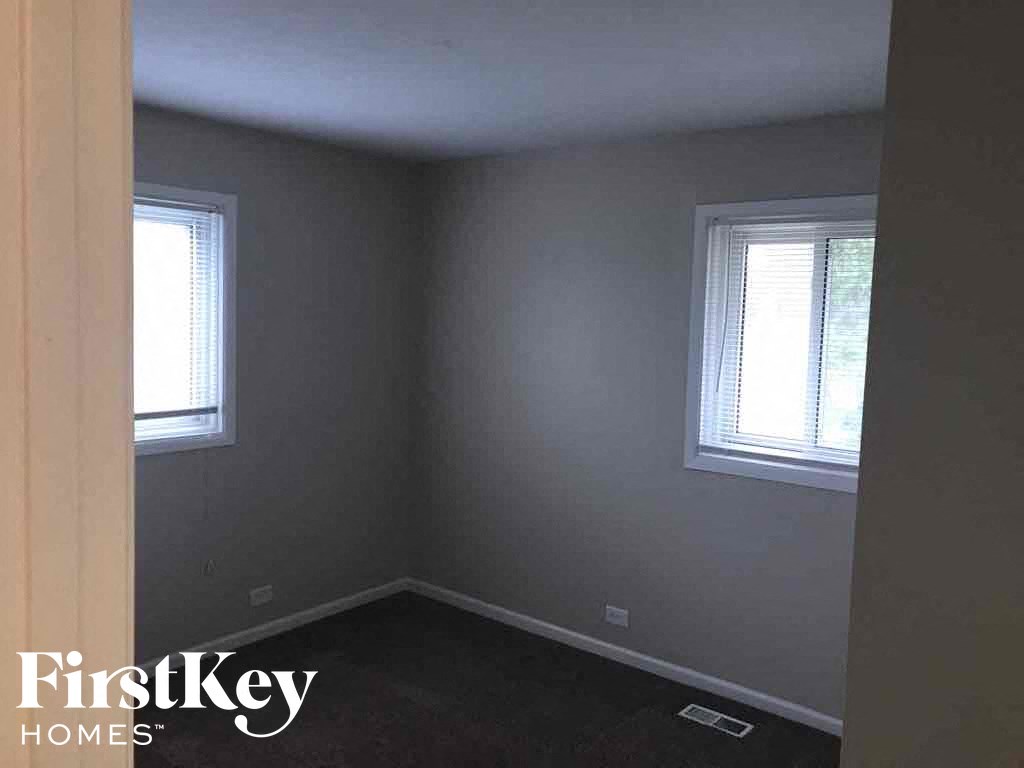 a small room with two windows and a black carpet