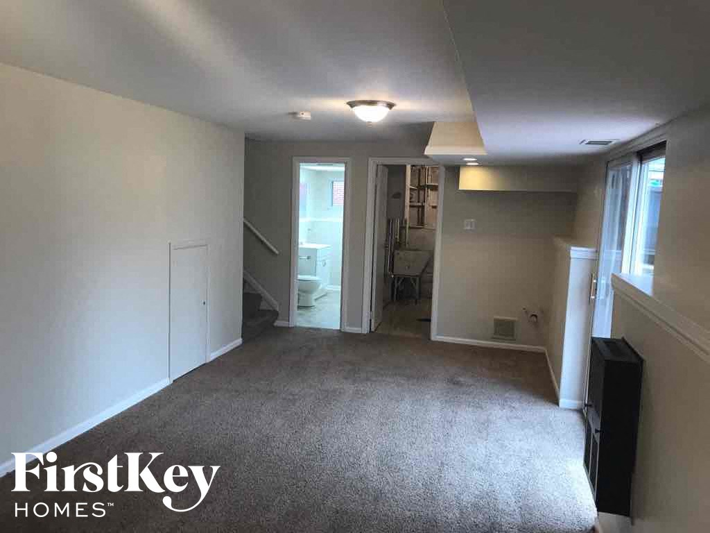 an empty living room with white walls and a carpeted floor