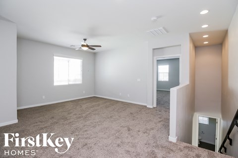a living room with carpet and a ceiling fan