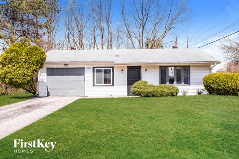 A house with a garage and a lawn in front.