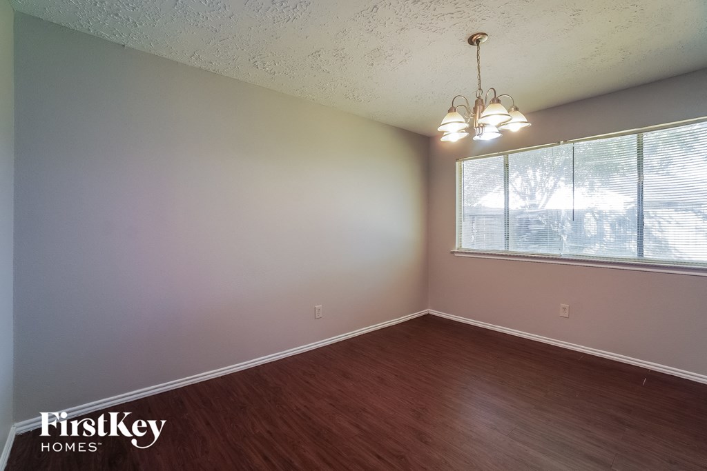 the living room of a house with wood floors and a large window