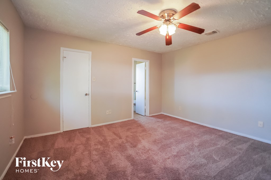 the living room of an empty house with a ceiling fan