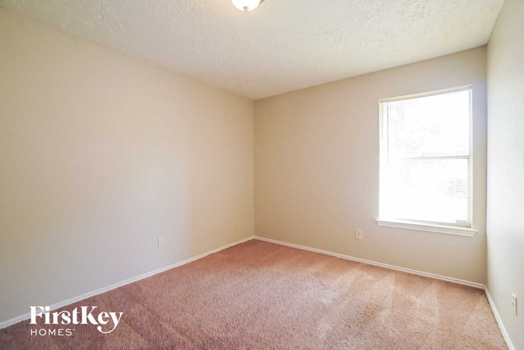 an empty room with carpet and a window