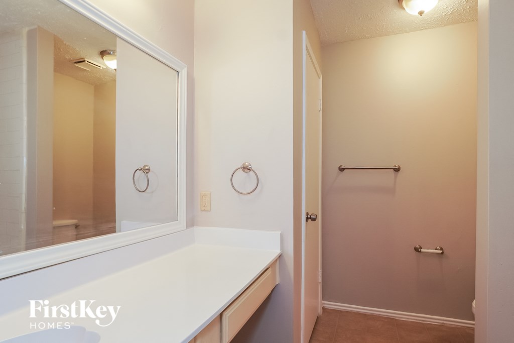 a bathroom with a large mirror and a white sink