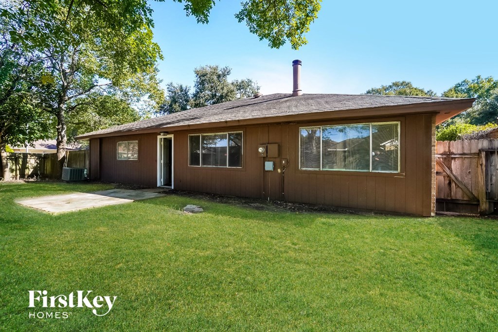 the front of a brown house with a yard and grass