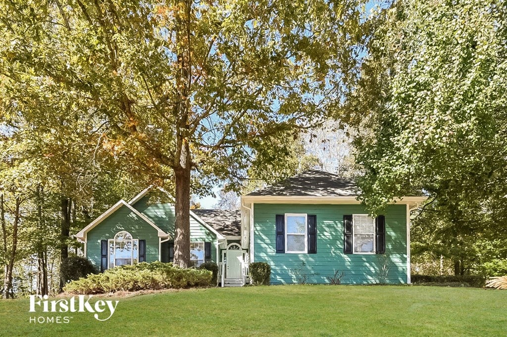 a small green house with trees in front of it