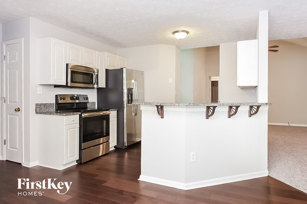 a kitchen with white cabinets and stainless steel appliances and a counter top