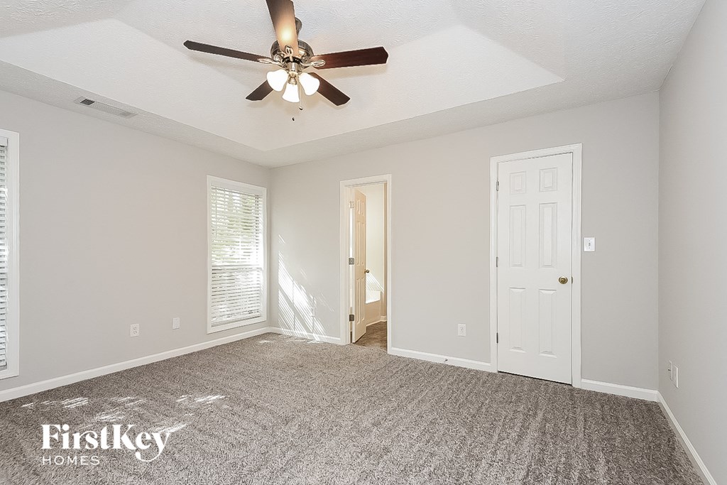 the living room of an empty house with a ceiling fan