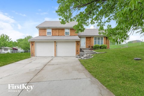 a home with a white garage door and a driveway