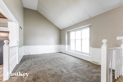 a bedroom with a carpeted floor and a large window
