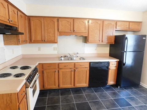 A kitchen with wooden cabinets and black appliances.