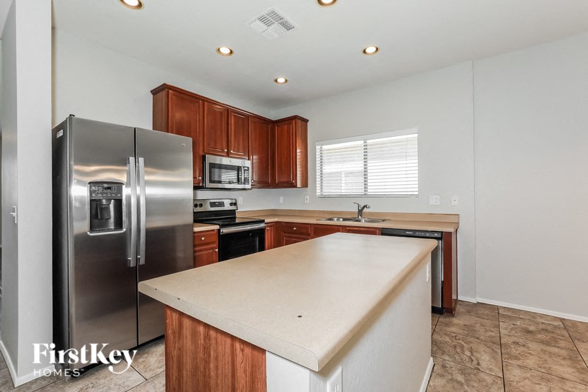 a kitchen with a white counter top and a stainless steel refrigerator