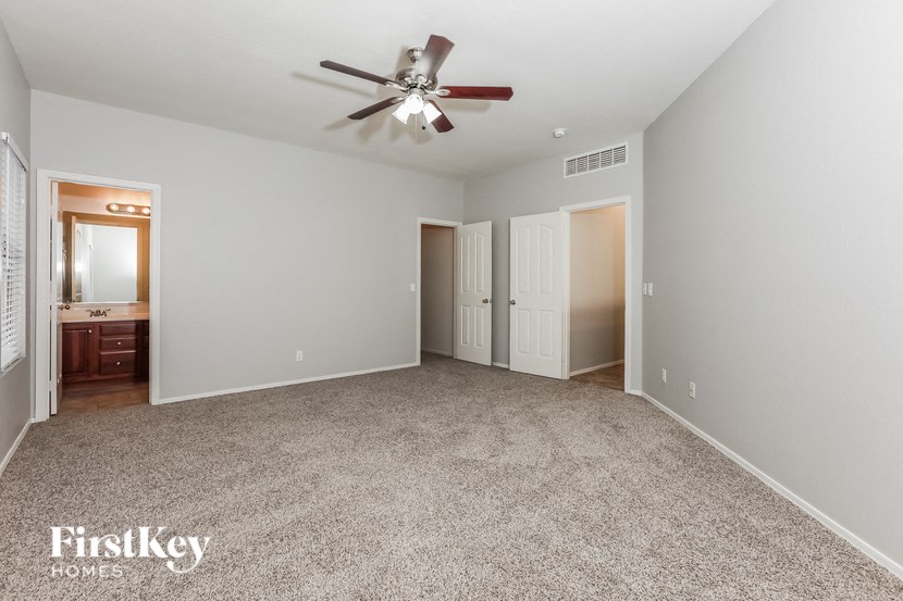 a spacious living room with a ceiling fan and carpeting