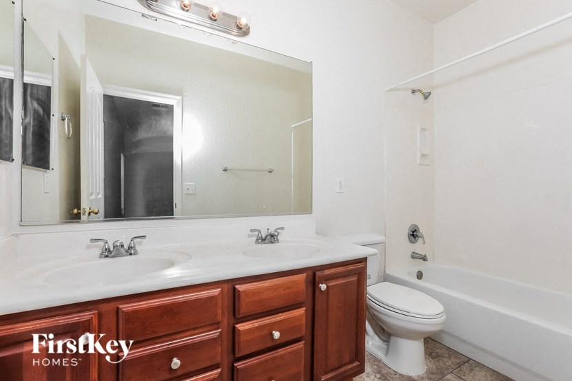a bathroom with two sinks and a toilet and a mirror