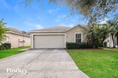 a beige house with a driveway and a garage door