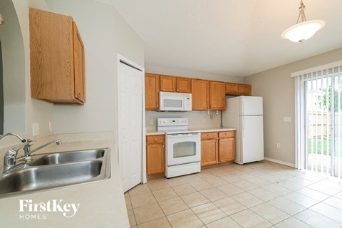 a kitchen with white appliances and wooden cabinets