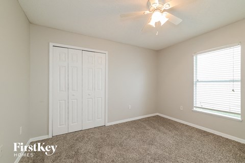 a bedroom with carpet and a ceiling fan