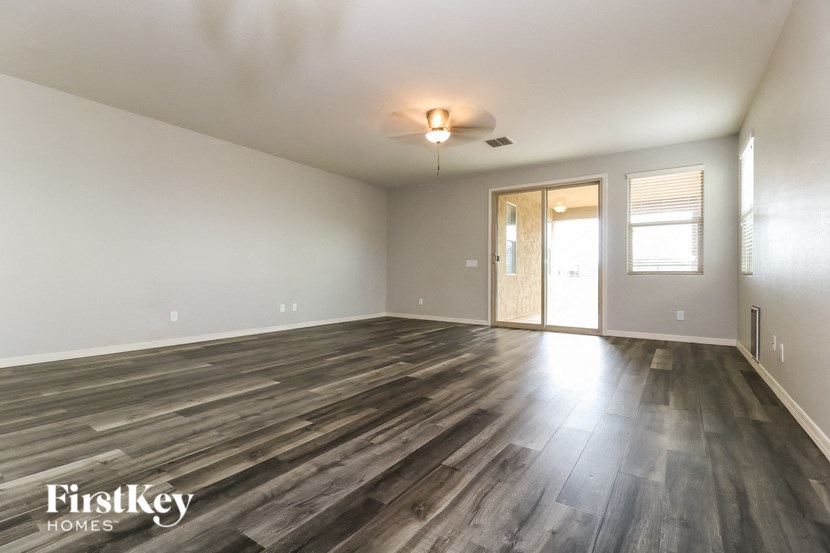 A spacious room with wooden flooring and a ceiling fan.