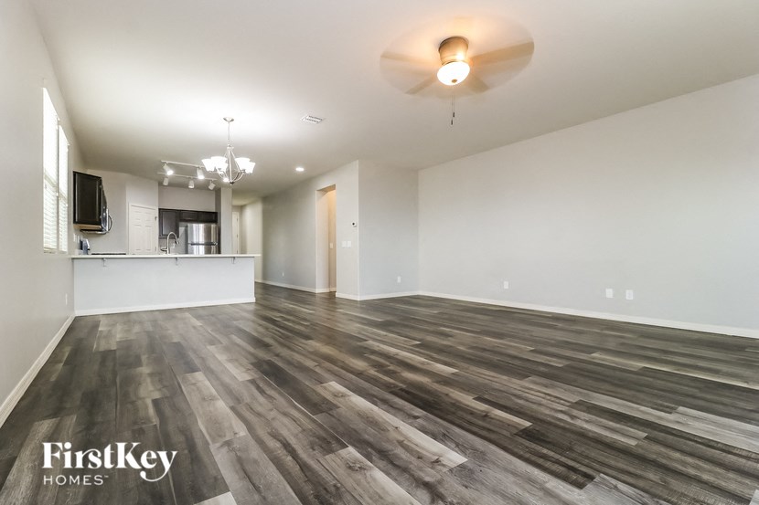 A spacious room with wooden flooring and a television mounted on the wall.
