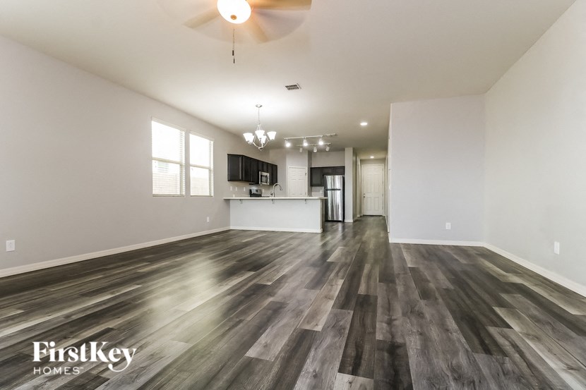 A spacious room with wooden flooring and a ceiling fan.