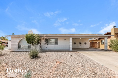 a small white house with a gravel driveway