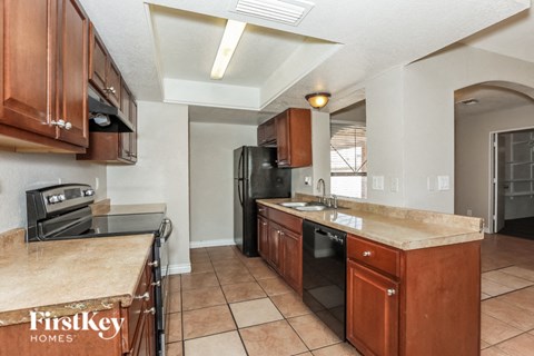 a kitchen with wooden cabinets and a black refrigerator