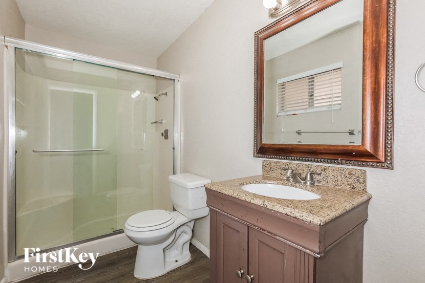 a bathroom with a shower toilet and sink and a mirror