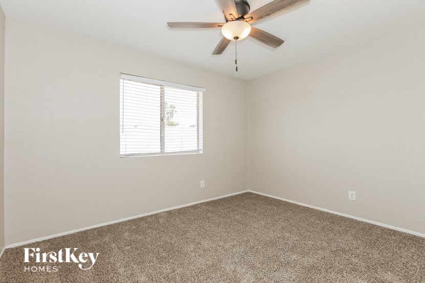 a bedroom with a ceiling fan and a window