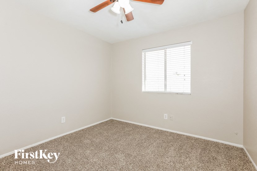 a empty room with a ceiling fan and a window