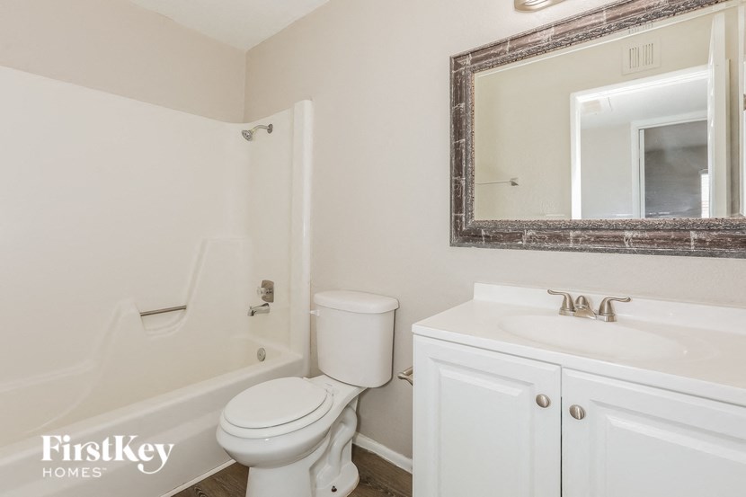 a bathroom with a sink toilet and a mirror