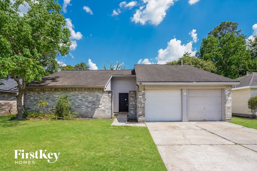 a white and gray brick house with a garage and a lawn