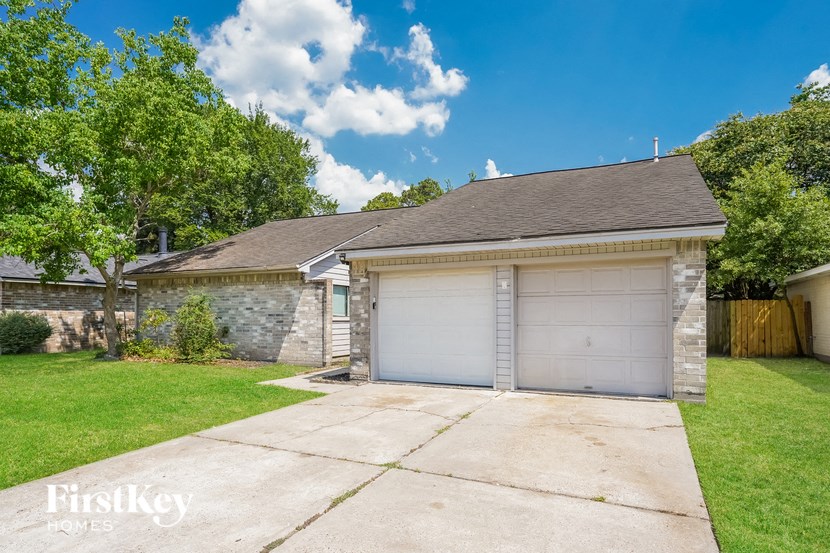 a brick garage with a white garage door in front of a green yard