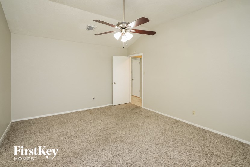 a bedroom with a ceiling fan and a carpeted floor