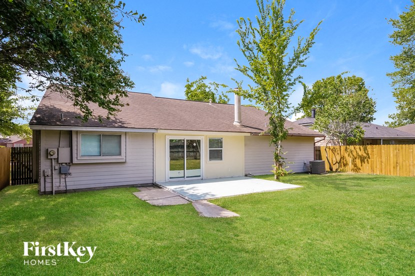 a small white house with a yard and a tree