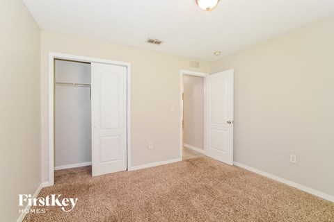 a master bedroom with two closets and a carpeted floor