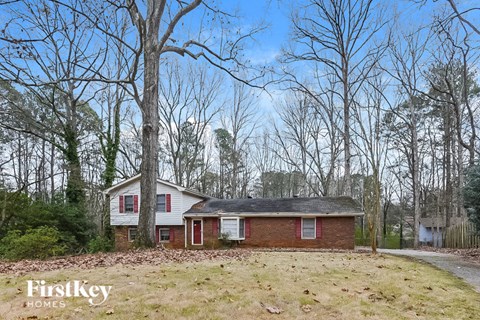 a small red brick house in the middle of the woods
